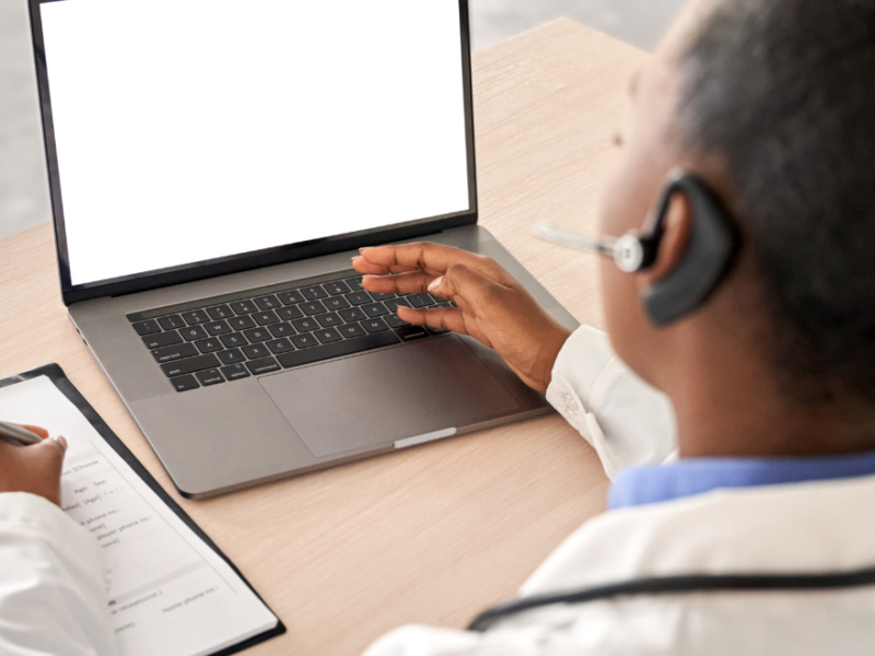 NHS professional looking at laptop at a desk