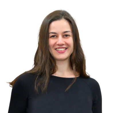 Anamaria, long brown hair, brown eyes, is smiling. She is wearing a black dress.