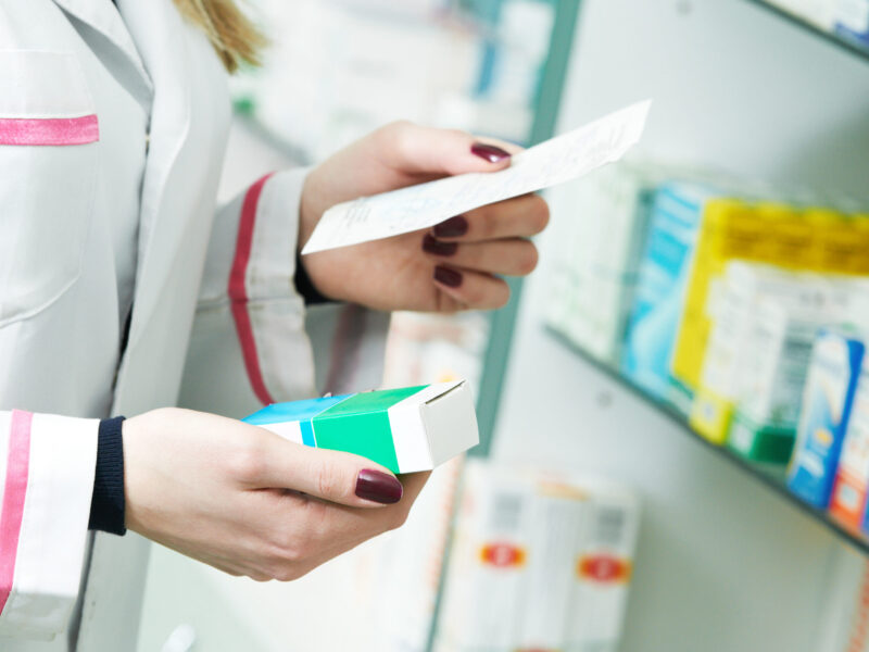 Closeup of pharmacist reading prescription of medicine