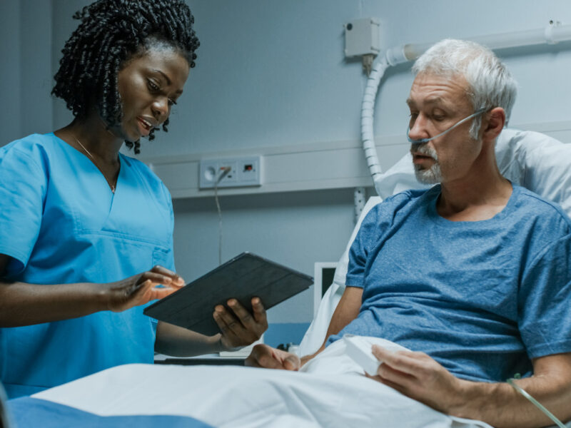 A nurse showing a patient notes on a tablet